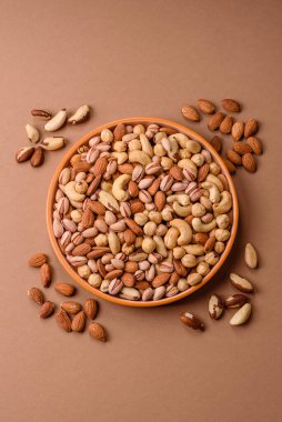 Sağlıklı gıda malzemesi olarak kaju, fıstık, badem, Brezilya fındığı, macadamia ve fındık karışımı. Tasarımınız için yemek arkaplanı olarak fındık