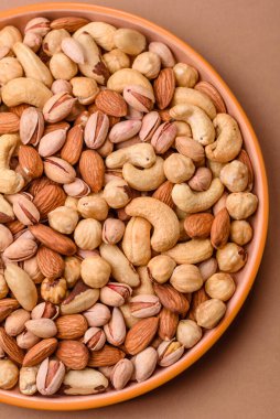 Sağlıklı gıda malzemesi olarak kaju, fıstık, badem, Brezilya fındığı, macadamia ve fındık karışımı. Tasarımınız için yemek arkaplanı olarak fındık
