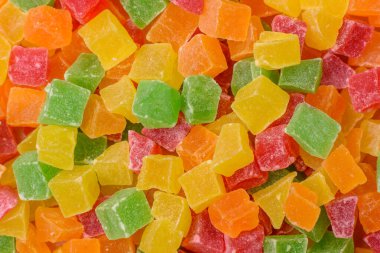 Şekerli meyveler rengarenk küplerde pişmiş yiyecekler ve tatlılar için bir malzemedir. Tasarımınız için gıda arka planı olarak şekerli meyve