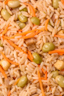 Pirinç, edamame, havuç, tofu ve baharatlı Asya yemekleri. Edamame ve havuçlu pilav tasarımınız için gıda arka planında.