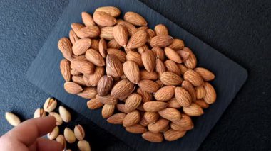 Çiğ ve soyulmuş badem sağlıklı bir besin maddesi. Tasarımınız için gıda arkaplanı olarak badem