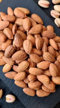 Çiğ ve soyulmuş badem sağlıklı bir besin maddesi. Tasarımınız için gıda arkaplanı olarak badem