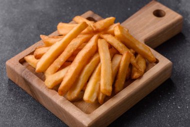 Patates kızartması, tuzlu, çıtır çıtır, ev yapımı baharatlı aperatif. Patates kızartması, tasarımınız için bir gıda arka planı.