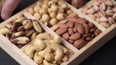 Sağlıklı gıda malzemesi olarak kaju, fıstık, badem, Brezilya fındığı, macadamia ve fındık karışımı. Tasarımınız için yemek arkaplanı olarak fındık