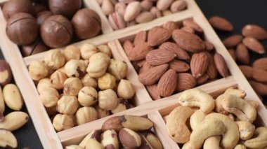 Sağlıklı gıda malzemesi olarak kaju, fıstık, badem, Brezilya fındığı, macadamia ve fındık karışımı. Tasarımınız için yemek arkaplanı olarak fındık