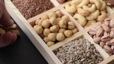 Sağlıklı gıda malzemesi olarak kaju, fıstık, badem, Brezilya fındığı, macadamia ve fındık karışımı. Tasarımınız için yemek arkaplanı olarak fındık