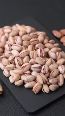 Sağlıklı, yüksek kalorili bir gıda malzemesi olarak kabuklu şam fıstığı. Tasarımınız için yemek arkaplanı olarak fıstıklar