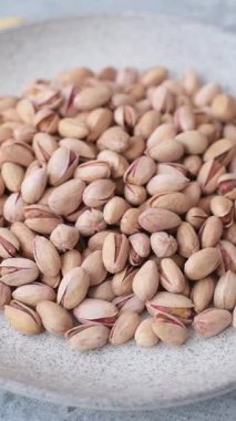 Sağlıklı, yüksek kalorili bir gıda malzemesi olarak kabuklu şam fıstığı. Tasarımınız için yemek arkaplanı olarak fıstıklar