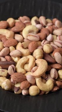 Sağlıklı gıda malzemesi olarak kaju, fıstık, badem, Brezilya fındığı, macadamia ve fındık karışımı. Tasarımınız için yemek arkaplanı olarak fındık