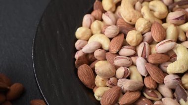 Sağlıklı gıda malzemesi olarak kaju, fıstık, badem, Brezilya fındığı, macadamia ve fındık karışımı. Tasarımınız için yemek arkaplanı olarak fındık