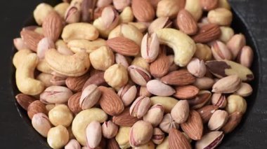 Sağlıklı gıda malzemesi olarak kaju, fıstık, badem, Brezilya fındığı, macadamia ve fındık karışımı. Tasarımınız için yemek arkaplanı olarak fındık