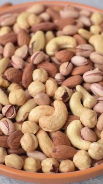 Sağlıklı gıda malzemesi olarak kaju, fıstık, badem, Brezilya fındığı, macadamia ve fındık karışımı. Tasarımınız için yemek arkaplanı olarak fındık