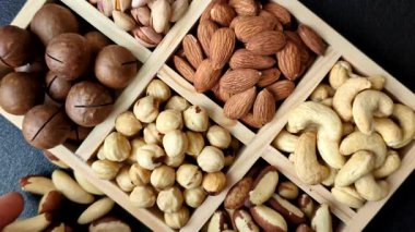 Sağlıklı gıda malzemesi olarak kaju, fıstık, badem, Brezilya fındığı, macadamia ve fındık karışımı. Tasarımınız için yemek arkaplanı olarak fındık