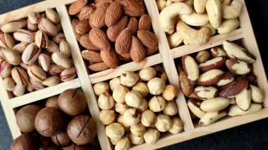 Sağlıklı gıda malzemesi olarak kaju, fıstık, badem, Brezilya fındığı, macadamia ve fındık karışımı. Tasarımınız için yemek arkaplanı olarak fındık