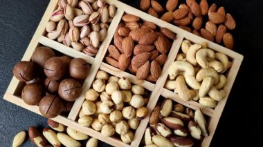 Sağlıklı gıda malzemesi olarak kaju, fıstık, badem, Brezilya fındığı, macadamia ve fındık karışımı. Tasarımınız için yemek arkaplanı olarak fındık