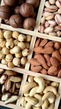 Sağlıklı gıda malzemesi olarak kaju, fıstık, badem, Brezilya fındığı, macadamia ve fındık karışımı. Tasarımınız için yemek arkaplanı olarak fındık