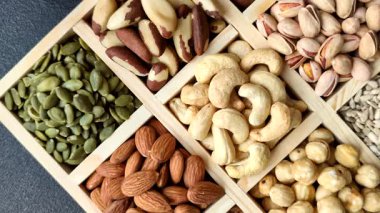 Sağlıklı gıda malzemesi olarak kaju, fıstık, badem, Brezilya fındığı, macadamia ve fındık karışımı. Tasarımınız için yemek arkaplanı olarak fındık