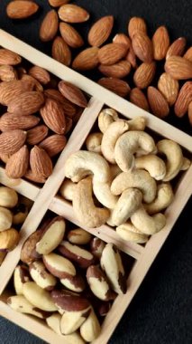 Sağlıklı gıda malzemesi olarak kaju, fıstık, badem, Brezilya fındığı, macadamia ve fındık karışımı. Tasarımınız için yemek arkaplanı olarak fındık