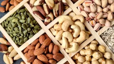 Sağlıklı gıda malzemesi olarak kaju, fıstık, badem, Brezilya fındığı, macadamia ve fındık karışımı. Tasarımınız için yemek arkaplanı olarak fındık