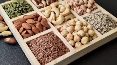 Sağlıklı gıda malzemesi olarak kaju, fıstık, badem, Brezilya fındığı, macadamia ve fındık karışımı. Tasarımınız için yemek arkaplanı olarak fındık