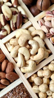 Sağlıklı gıda malzemesi olarak kaju, fıstık, badem, Brezilya fındığı, macadamia ve fındık karışımı. Tasarımınız için yemek arkaplanı olarak fındık