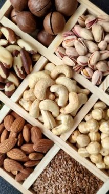 Sağlıklı gıda malzemesi olarak kaju, fıstık, badem, Brezilya fındığı, macadamia ve fındık karışımı. Tasarımınız için yemek arkaplanı olarak fındık