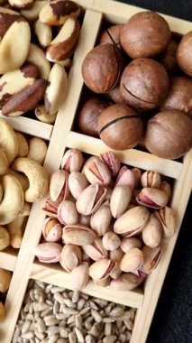 Sağlıklı gıda malzemesi olarak kaju, fıstık, badem, Brezilya fındığı, macadamia ve fındık karışımı. Tasarımınız için yemek arkaplanı olarak fındık