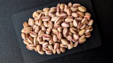 Sağlıklı, yüksek kalorili bir gıda malzemesi olarak kabuklu şam fıstığı. Tasarımınız için yemek arkaplanı olarak fıstıklar