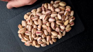 Sağlıklı, yüksek kalorili bir gıda malzemesi olarak kabuklu şam fıstığı. Tasarımınız için yemek arkaplanı olarak fıstıklar