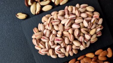 Sağlıklı, yüksek kalorili bir gıda malzemesi olarak kabuklu şam fıstığı. Tasarımınız için yemek arkaplanı olarak fıstıklar