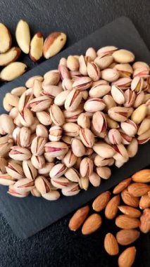 Sağlıklı, yüksek kalorili bir gıda malzemesi olarak kabuklu şam fıstığı. Tasarımınız için yemek arkaplanı olarak fıstıklar