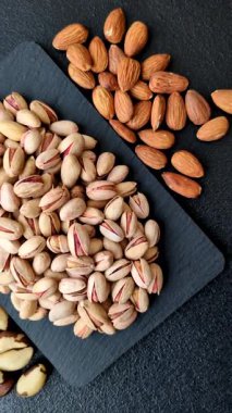 Sağlıklı, yüksek kalorili bir gıda malzemesi olarak kabuklu şam fıstığı. Tasarımınız için yemek arkaplanı olarak fıstıklar