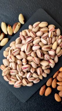 Sağlıklı, yüksek kalorili bir gıda malzemesi olarak kabuklu şam fıstığı. Tasarımınız için yemek arkaplanı olarak fıstıklar