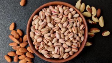 Sağlıklı, yüksek kalorili bir gıda malzemesi olarak kabuklu şam fıstığı. Tasarımınız için yemek arkaplanı olarak fıstıklar