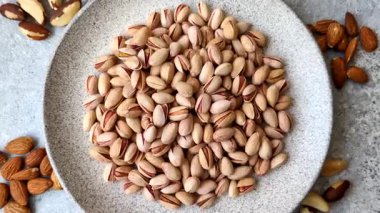 Sağlıklı, yüksek kalorili bir gıda malzemesi olarak kabuklu şam fıstığı. Tasarımınız için yemek arkaplanı olarak fıstıklar