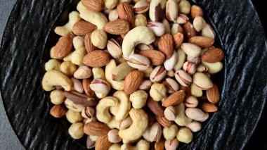 Sağlıklı gıda malzemesi olarak kaju, fıstık, badem, Brezilya fındığı, macadamia ve fındık karışımı. Tasarımınız için yemek arkaplanı olarak fındık