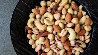 Sağlıklı gıda malzemesi olarak kaju, fıstık, badem, Brezilya fındığı, macadamia ve fındık karışımı. Tasarımınız için yemek arkaplanı olarak fındık