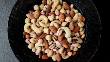 Sağlıklı gıda malzemesi olarak kaju, fıstık, badem, Brezilya fındığı, macadamia ve fındık karışımı. Tasarımınız için yemek arkaplanı olarak fındık