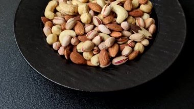 Sağlıklı gıda malzemesi olarak kaju, fıstık, badem, Brezilya fındığı, macadamia ve fındık karışımı. Tasarımınız için yemek arkaplanı olarak fındık