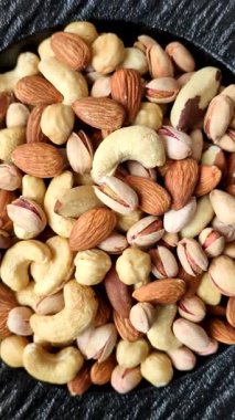 Sağlıklı gıda malzemesi olarak kaju, fıstık, badem, Brezilya fındığı, macadamia ve fındık karışımı. Tasarımınız için yemek arkaplanı olarak fındık