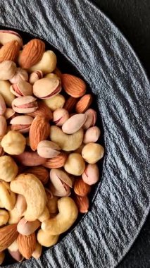 Sağlıklı gıda malzemesi olarak kaju, fıstık, badem, Brezilya fındığı, macadamia ve fındık karışımı. Tasarımınız için yemek arkaplanı olarak fındık