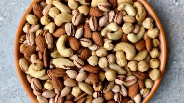 Sağlıklı gıda malzemesi olarak kaju, fıstık, badem, Brezilya fındığı, macadamia ve fındık karışımı. Tasarımınız için yemek arkaplanı olarak fındık