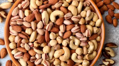 Sağlıklı gıda malzemesi olarak kaju, fıstık, badem, Brezilya fındığı, macadamia ve fındık karışımı. Tasarımınız için yemek arkaplanı olarak fındık