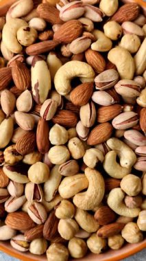 Sağlıklı gıda malzemesi olarak kaju, fıstık, badem, Brezilya fındığı, macadamia ve fındık karışımı. Tasarımınız için yemek arkaplanı olarak fındık