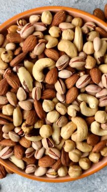 Sağlıklı gıda malzemesi olarak kaju, fıstık, badem, Brezilya fındığı, macadamia ve fındık karışımı. Tasarımınız için yemek arkaplanı olarak fındık