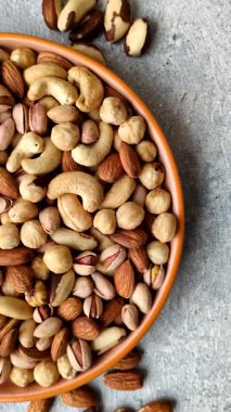 Sağlıklı gıda malzemesi olarak kaju, fıstık, badem, Brezilya fındığı, macadamia ve fındık karışımı. Tasarımınız için yemek arkaplanı olarak fındık