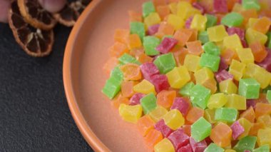 Şekerli meyveler rengarenk küplerde pişmiş yiyecekler ve tatlılar için bir malzemedir. Tasarımınız için gıda arka planı olarak şekerli meyve