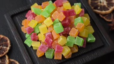 Şekerli meyveler rengarenk küplerde pişmiş yiyecekler ve tatlılar için bir malzemedir. Tasarımınız için gıda arka planı olarak şekerli meyve