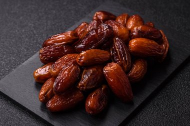 Ramazan ya da iftar için seramik bir tabakta kurutulmuş tarihler. Tasarımınız için kuru tarihler gıda arka planı olarak kullanılacaktır