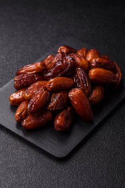 Ramazan ya da iftar için seramik bir tabakta kurutulmuş tarihler. Tasarımınız için kuru tarihler gıda arka planı olarak kullanılacaktır